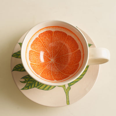 KHANOOM tea cup and saucer orange  striking orange motif with white backdrop