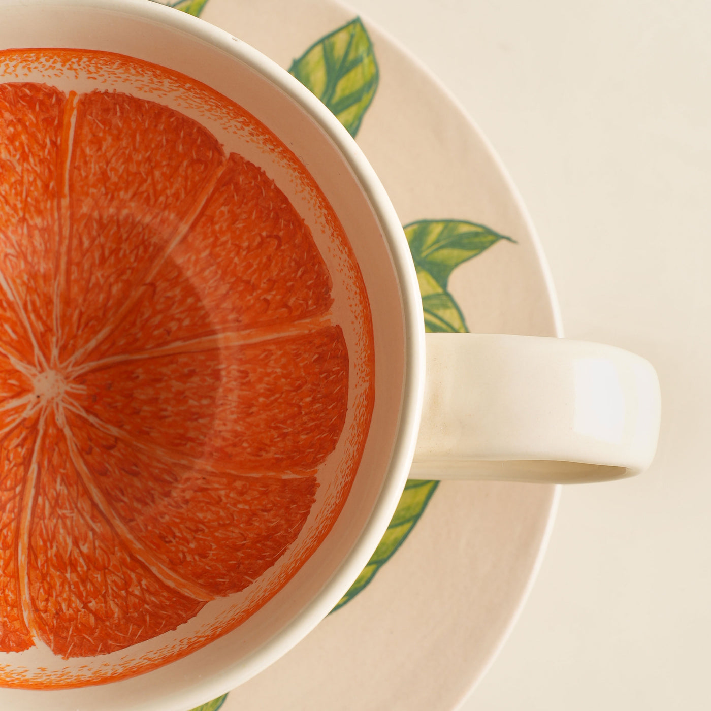 KHANOOM tea cup and saucer orange  striking orange motif with white backdrop