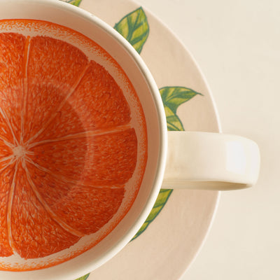 KHANOOM tea cup and saucer orange  striking orange motif with white backdrop