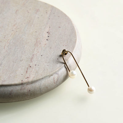 Curved Pearl Earrings from The Line on a 18K gold setting 